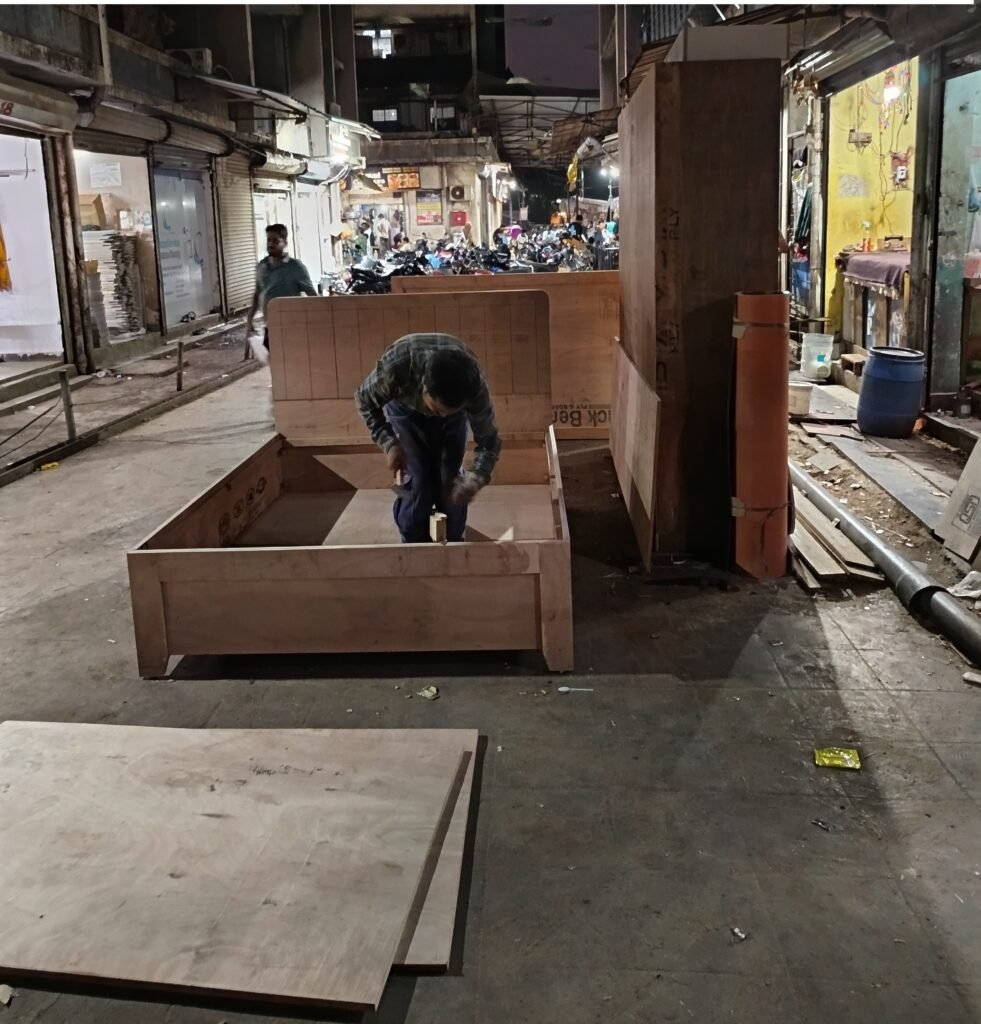 Worker assembling custom wooden bed frame in furniture workshop